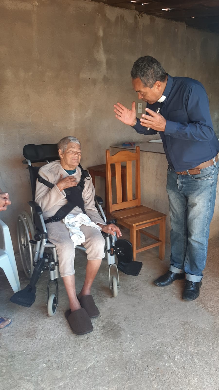 Padre Amauri abençoando um idoso enfermo