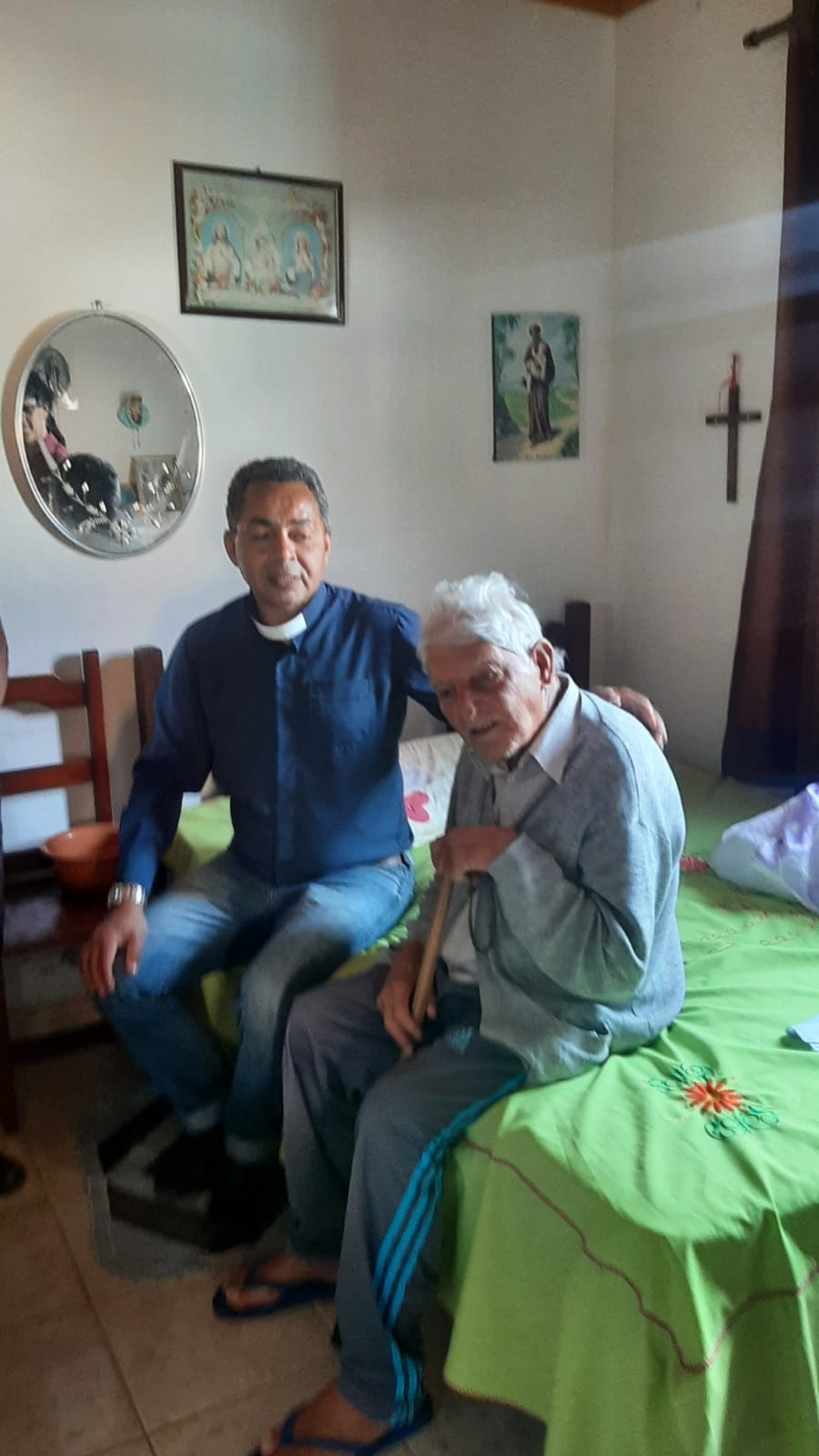 Padre Amauri em oração com um idoso